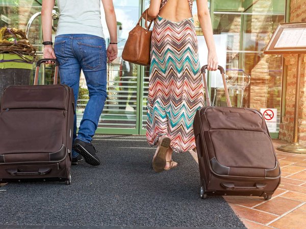 A couple arrives with their luggage for a relaxing all-inclusive vacation.
