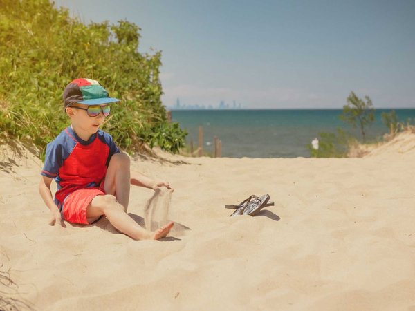 Boy sitting on a dune at Indiana Dunes National Park, Chicago sk