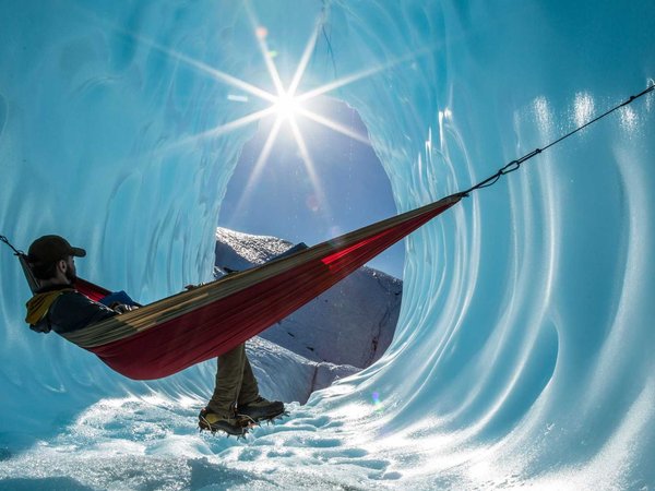 Sitting in a hammock inside the entrance of an ice cave in a gla