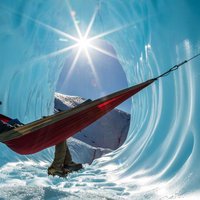 Sitting in a hammock inside the entrance of an ice cave in a gla