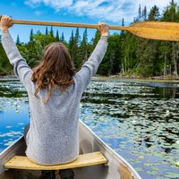 Woman paddling canoe in lake during holiday