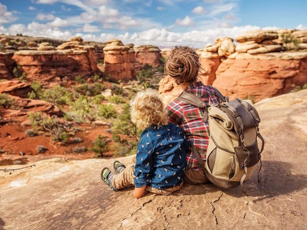 Hiker with boy in Canyonlands National park, needles in the sky, in Utah, USA