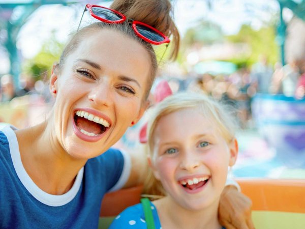 Mother and daughter smile with joy on a ride at Disneyland in California