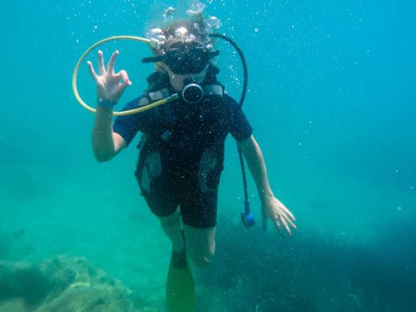Summer vacation in  Corfu Greece . Young women having scuba diving  into the mediteranean sea.