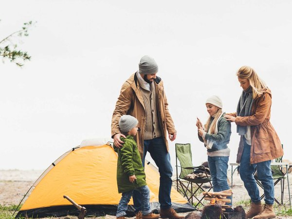 A family that has their tent setup and campsite ready for a fall campout