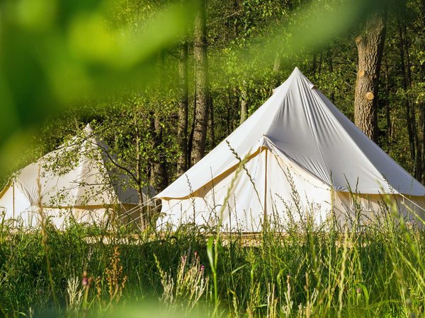 A canvas tents and a semi permanent deck often used for glamping