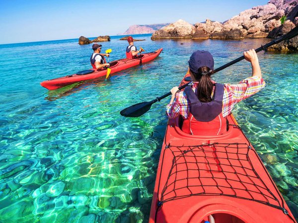 Friends meet at the kayak rental to pick up their boat and paddle in the sea