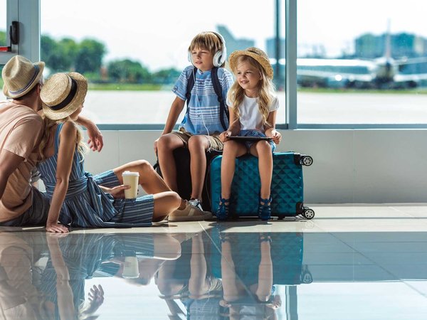 Family taking a break in the airport while traveling to their vacation destination