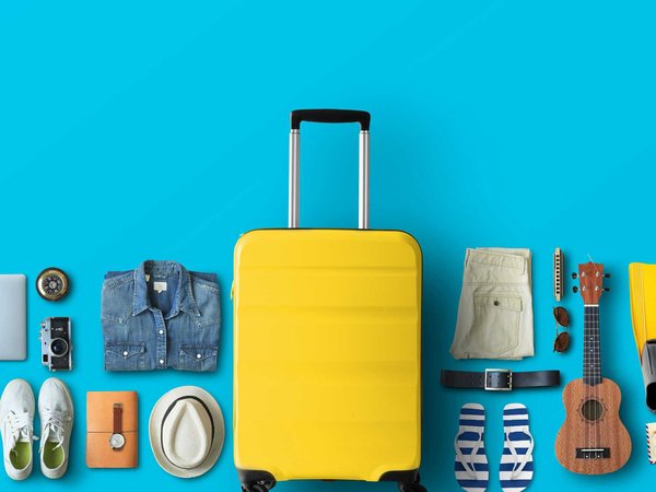 Suitcase and sample of items to pack for a sailing charter in Hawaii