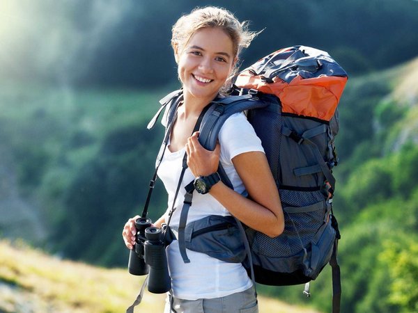A happy hiker who is prepared with a full pack