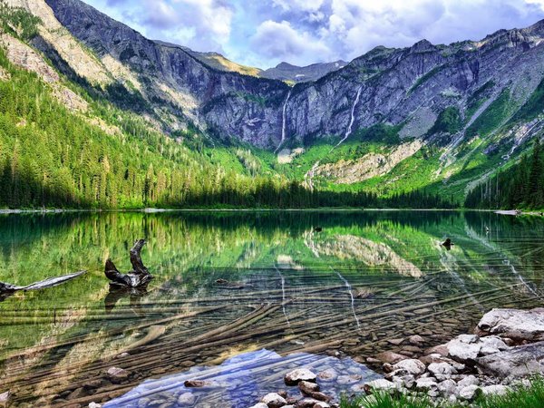 gorgeous sunlit Avalanche lake with reflection in Glacier National Park