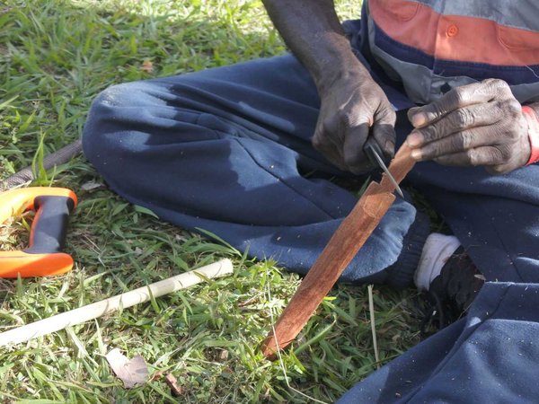 Indigenous Australians aboriginal craftman making a a wooden Australian Aboriginal spear