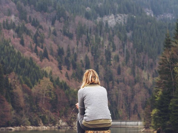 woman meditating on a lake shore