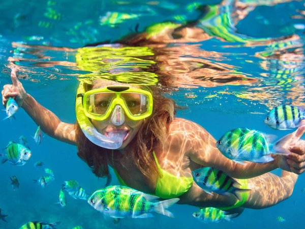 Girl in snorkeling mask dive underwater with coral reef fishes