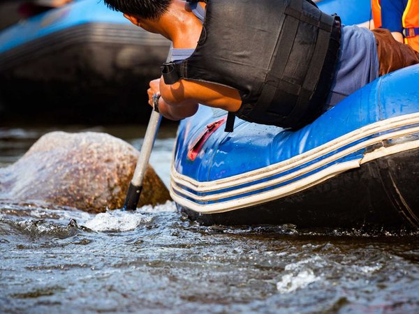 Close-up of young person rafting on the river, extreme and fun s