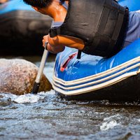 Close-up of young person rafting on the river, extreme and fun s