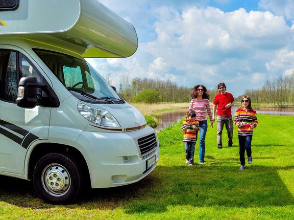 Parents and two kids head back to their RV after exploring the river