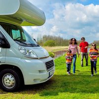 Parents and two kids head back to their RV after exploring the river