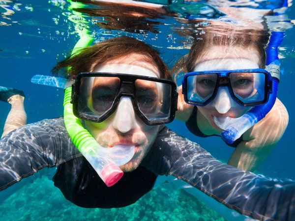 Adventurous couple goes snorkeling along the shores of Hawaii