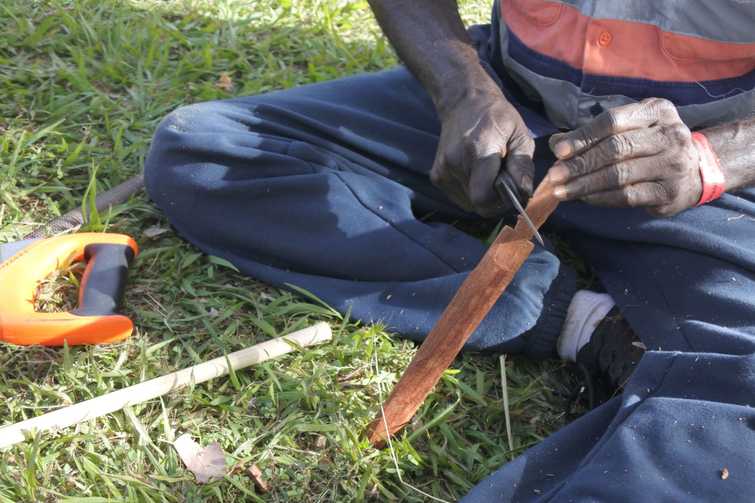 Indigenous Australians aboriginal craftman making a  a wooden Australian Aboriginal spear
