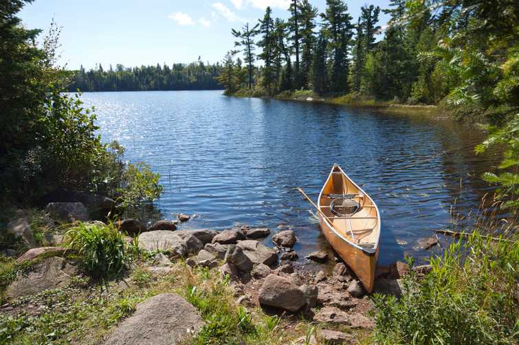 A fisherman's canoe on rocky shore in northern Minnesota lake