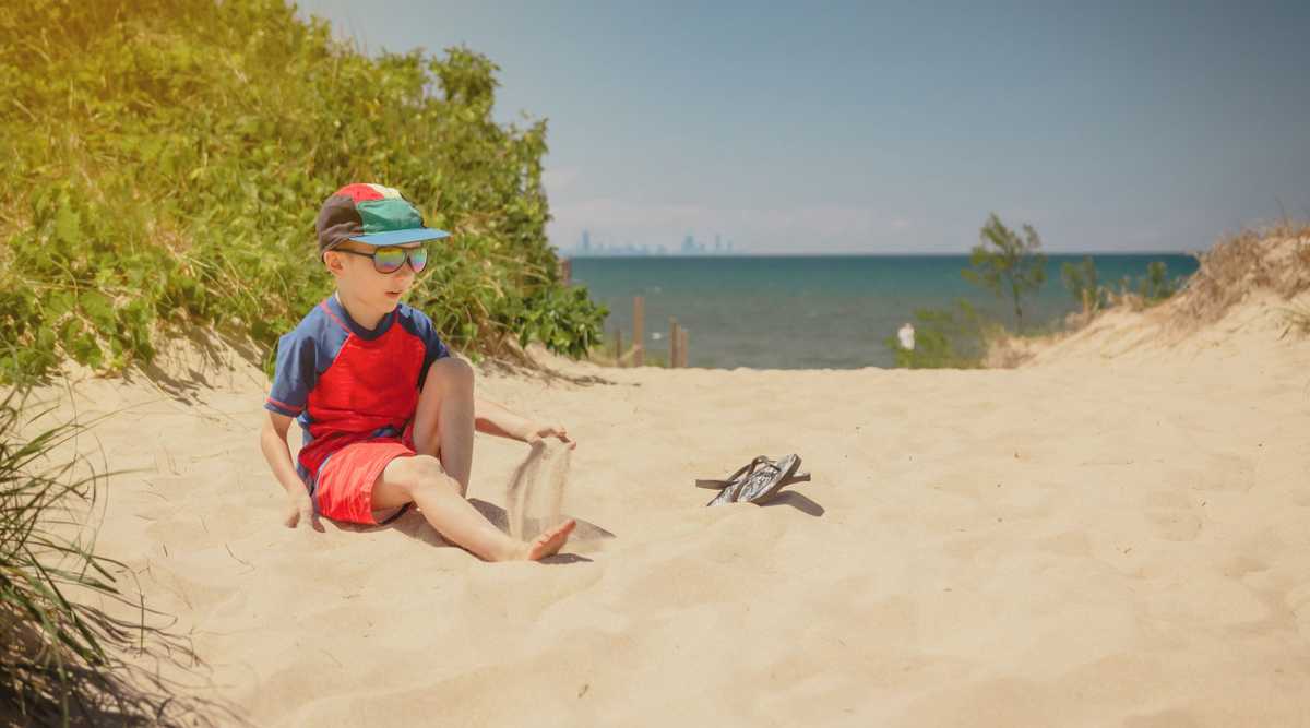 Boy sitting on a dune at Indiana Dunes National Park, Chicago sk