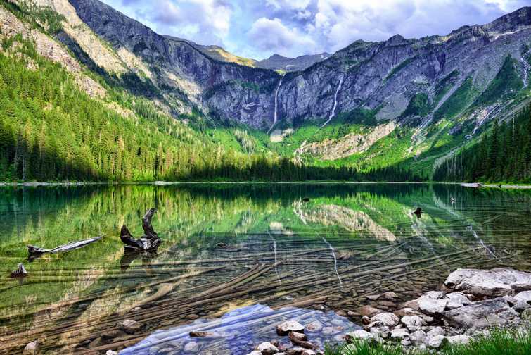 gorgeous sunlit Avalanche lake with reflection in Glacier National Park