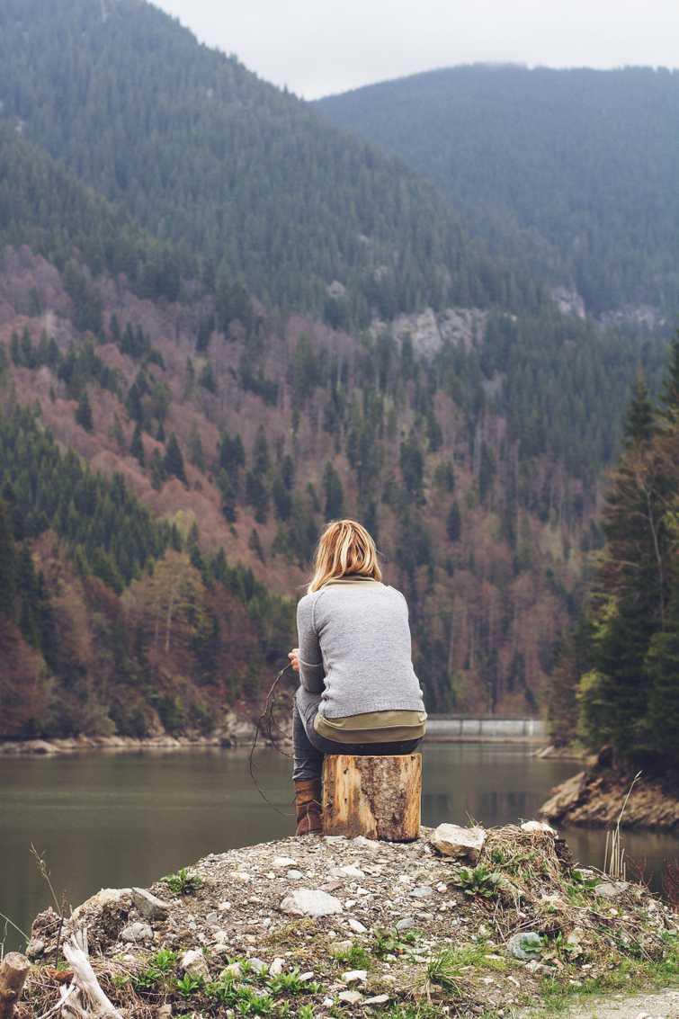 woman meditating on a lake shore