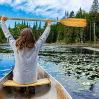 Woman paddling canoe in lake during holiday