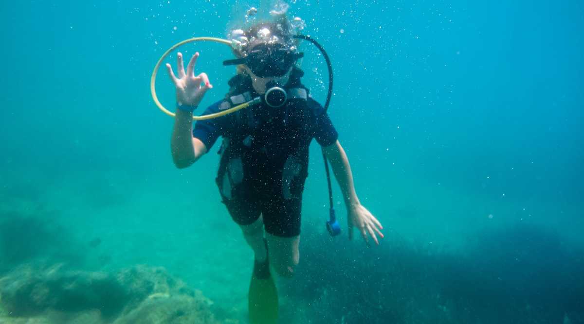 Summer vacation in  Corfu Greece . Young women having scuba diving  into the mediteranean sea.