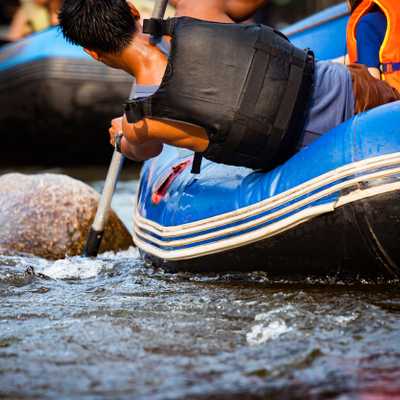 Close-up of young person rafting on the river, extreme and fun s