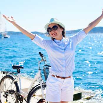 Young woman riding city bicycle near sea