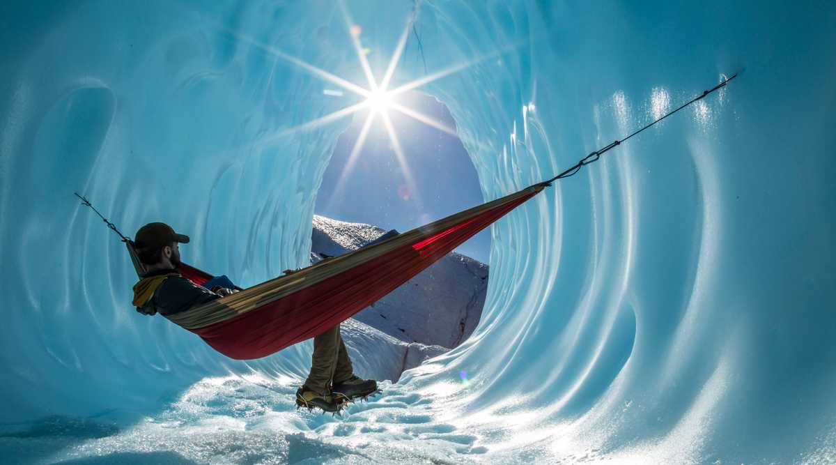 Sitting in a hammock inside the entrance of an ice cave in a gla