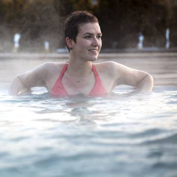 Young woman relaxing in thermal pool.