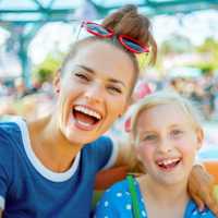 Mother and daughter smile with joy on a ride at Disneyland in California