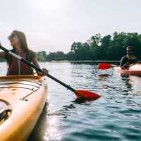 Ready for adventures. Beautiful young smiling couple kayaking on lake together